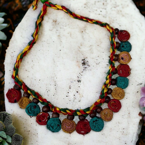 Mehrfarbige Baumwollfaden geflochtene Boho-Halskette mit Holzperlen und kleinen Rollen aus recyceltem Seiden-Saree-Material befestigt.