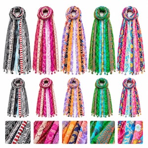 May include: A collection of five long scarves featuring vertical panels of diverse patterns and colours, including black and white, pink, orange, green, and floral prints. Each scarf is finished with small tassels along the bottom edge.