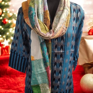 Peut inclure: Une tunique à motifs bleus et blancs avec une écharpe en patchwork colorée. L'écharpe est faite de différents tissus et couleurs, notamment le vert, le jaune, l'orange et le rose.