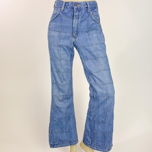 May include: Light blue denim jeans with a grid pattern. The jeans have a high waist and a flared leg. The jeans are displayed on a mannequin.