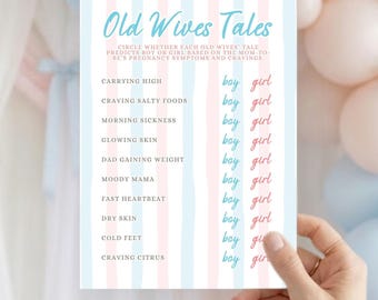 May include: A gender reveal game card with the text "Old Wives Tales" in a light blue font. The card has a pink and blue striped background and lists pregnancy symptoms with "boy" or "girl" options.