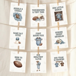 Puede incluir: Nueve tarjetas rectangulares blancas colgadas de un cordel con pinzas de madera. Cada tarjeta presenta ilustraciones en acuarela con temática de fútbol americano y textos como Huddle & Cuddle, Touchdowns & Tiny Toes, Our Little Rookie, Same Day Cutie, First Round Pick, Scoring Sweet Snuggles, Born To Score, Our Greatest Catch y Our Team Is Growing.
