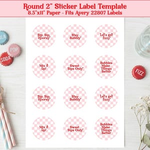 May include: A sheet of round stickers with pink and white checkered patterns and various phrases like "Sip, Sip, Hooray" and "Let's get fizzy." The image includes soda bottle caps and straws. The sticker labels are 2 inches in diameter.
