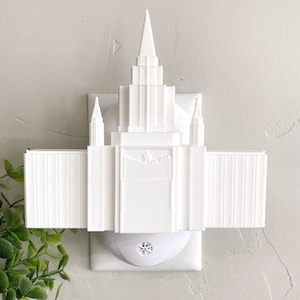 May include: White plastic nightlight shaped like a temple with a white electrical outlet plug.