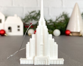 Puede incluir: Adorno blanco impreso en 3D con forma de edificio de iglesia con una aguja puntiaguda. El adorno tiene una cuerda plateada para colgar.