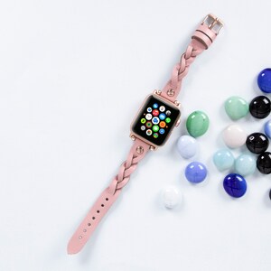 K&ouml;nnte beinhalten: Ein rosafarbenes geflochtenes Lederarmband f&uuml;r eine Apple Watch mit ros&eacute;goldener Oberfl&auml;che. Das Zifferblatt der Uhr ist sichtbar und zeigt den Apple Watch-Startbildschirm mit verschiedenen App-Symbolen.