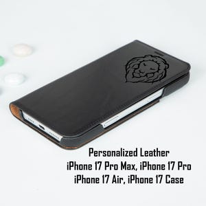 May include: Black leather phone case with a lion's head design. The case is closed, showing the engraved lion image. The text "Personalized Leather" and phone model compatibility are also visible.