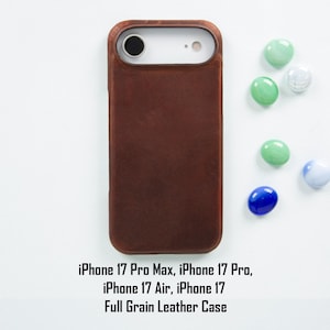 Könnte beinhalten: Eine braune Vollnarbenlederhülle für iPhone 17 Pro Max, iPhone 17 Pro, iPhone 17 Air und iPhone 17. Die Hülle wird mit bunten dekorativen Steinen gezeigt. Der Text auf dem Bild lautet: iPhone 17 Pro Max, iPhone 17 Pro, iPhone 17 Air, iPhone 17 Full Grain Leather Case.