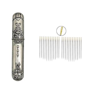 May include: A silver needle case with ornate floral and scrollwork designs, accompanied by a collection of sewing needles. The needles have gold-colored eyes. The case is cylindrical and has a hinged lid.