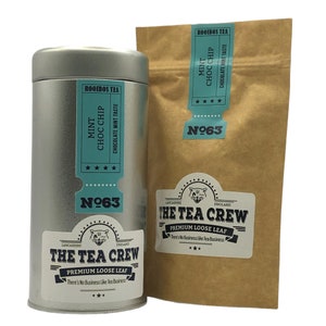 Könnte beinhalten: Eine silberne Dose und ein brauner Papierbeutel mit losen Blatttee. Sowohl die Dose als auch der Beutel haben ein Etikett mit dem Text "The Tea Crew" und "Premium Loose Leaf". Das Etikett enthält auch den Text "Rooibos Tea" und "Mint Choc Chip" mit einem Geschmack nach Schokoladenminze. Das Etikett enthält auch den Text "There's No Business Like Tea Business".