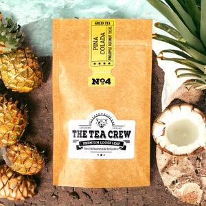 Peut inclure: Un sachet en papier brun avec une étiquette jaune qui dit "Green Tea Pina Colada Pineapple Coconut Taste" et "Nº4". L'étiquette indique également "The Tea Crew Premium Loose Leaf There's No Business Like Tea Business".