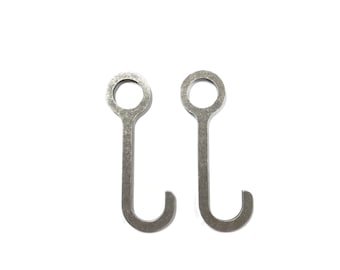 May include: Two silver metal hooks with a circular loop at the top and a hook at the bottom.