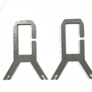May include: Two silver metal brackets with a rectangular opening and a Y-shaped base.