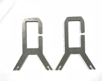 May include: Two silver metal brackets with a rectangular opening and a Y-shaped base.
