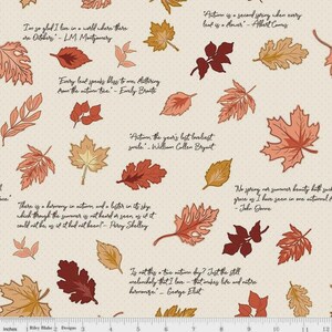 May include: A cream-colored fabric featuring a repeating pattern of various autumn leaves in shades of orange, red, and brown, interspersed with printed literary quotes about the fall season, with a visible 12-inch ruler along the bottom edge.