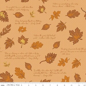 May include: A light brown fabric featuring a repeating pattern of various autumn leaves in shades of orange, yellow, and brown. The design includes several literary quotes about autumn printed in a cursive script, with a ruler visible at the bottom.