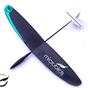 Puede incluir: Un planeador Microbirds Ultralight negro y turquesa con cola y ala blancas. El planeador tiene un dise&ntilde;o elegante con el logotipo de Microbirds en blanco. El ala tiene un acento turquesa. El planeador est&aacute; sobre un fondo blanco.