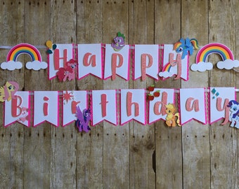 May include: A pink and white banner with the words "Happy Birthday" in pink glitter letters. The banner is decorated with My Little Pony characters and rainbows.