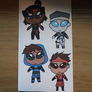 May include: Four cartoon character stickers. The characters are drawn in a chibi style, each with large oval eyes. They are dressed in ninja-like outfits in black, blue, red, and white. The stickers are on a white background.
