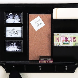 May include: Black wall organizer with a corkboard, three picture frames, a shelf for magazines, and hooks for hanging items. The corkboard has a note that says "Dentist @ 9:00am".