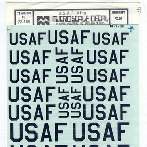 May include: A sheet of 1/72 scale decals for model aircraft. The decals feature the words "USAF" repeated multiple times in a black font on a light blue background. The sheet is labeled "Microscale Decal" and "U.S.A.F. Wing".