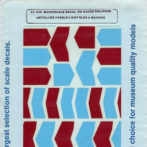 May include: A sheet of HO scale model railroad decals for antiglare panels. The decals are light blue and maroon and feature arrow shapes. The sheet is labeled "87-449 Microscale Decal HO Gauge Railroad Antiglare Panels Light Blue & Maroon".
