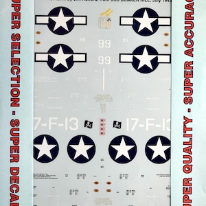May include: A sheet of waterslide decals for an F4U-1/FG-1 Corsair model aircraft, featuring white star-and-bar insignias, the text 'SKIPPERS ORCHID', '17-F-13', and various technical markings on a light blue backing with red border text.