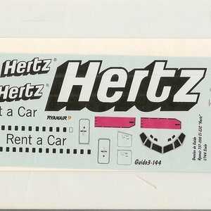 May include: A white sheet of paper with a black and white Hertz logo and the text "Rent a Car" repeated twice. The sheet also includes a black and white airplane with the text "EI-CJC" and a small Italian flag.