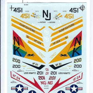 May include: Decal sheet for a model airplane with a yellow, red, and blue color scheme. The sheet includes the numbers 200, 451, and 201, as well as the text "VF-24", "VF-21", "NG NG", "USS NIMITZ", "GUNFIGHTERS", and "NAVY".