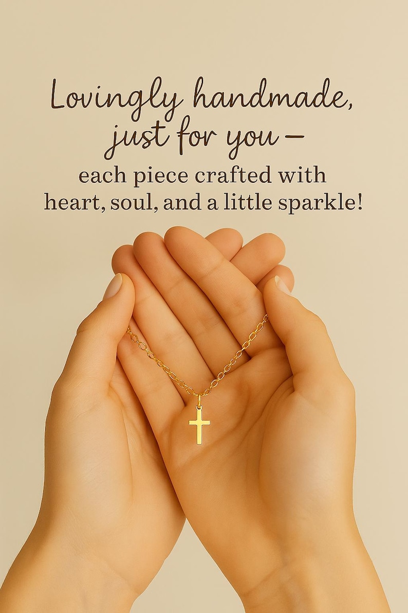 May include: A gold-coloured necklace with a small cross pendant. The text above reads: Lovingly handmade, just for you - each piece crafted with heart, soul, and a little sparkle! The chain features delicate links and a simple cross charm.