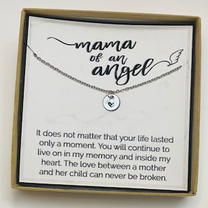 May include: A silver necklace with a small heart charm pendant in a box with a message that reads "mama of an angel" and "It does not matter that your life lasted only a moment. You will continue to live on in my memory and inside my heart. The love between a mother and her child can never be broken."