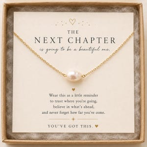 May include: A gold chain necklace featuring a single white freshwater pearl pendant, presented on a cream-colored card with the text THE NEXT CHAPTER is going to be a beautiful one. Wear this as a little reminder to trust where you're going, believe in what's ahead, and never forget how far you've come. YOU'VE GOT THIS.