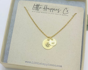 May include: Gold necklace with a baseball charm and a small heart charm. The necklace is in a box with the text "Little Happies Co. It is more blessed to give than to receive." and "www.littlehappiesco.com".