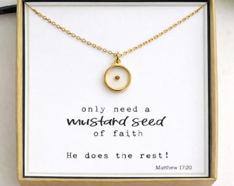 Op de afbeelding: Een goudkleurige ketting met een ronde hanger die een enkel mosterdzaadje bevat, gepresenteerd in een vierkante doos met de tekst: only need a mustard seed of faith He does the rest! Matthew 17:20 gedrukt op de witte kaart in de doos.