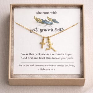 May include: Gold-colored necklace with a cross and a running figure pendant, presented in a small, light brown box. The card inside reads "she runs with grit, grace & faith" and a Bible verse.