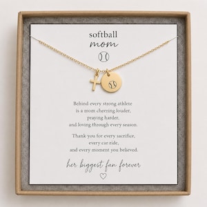 Könnte beinhalten: Eine goldfarbene Halskette mit einem Kreuzanhänger und einem runden Anhänger mit Softball-Grafik. Der Schmuck ist auf einer weißen Karte befestigt, die mit dem Text softball mom, einem Softball-Symbol und einem Text über Sportler bedruckt ist.
