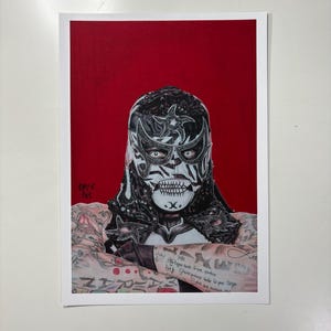 Puede incluir: Una lámina de arte rectangular con la ilustración de un luchador que lleva una máscara negra y blanca con motivos de estrellas y un diseño de boca esquelética. La figura tiene los brazos tatuados cruzados sobre un fondo rojo sólido.