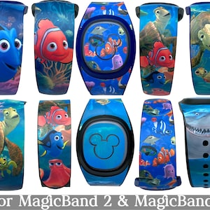 May include: A collection of MagicBand 2 and MagicBand+ accessories featuring characters from the animated film "Finding Nemo." Designs include Dory, Nemo, Crush, and Bruce the shark, set against a blue ocean background. The text "for MagicBand 2 & MagicBand+" is at the bottom.