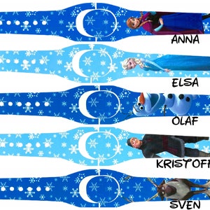May include: Five blue and white wristbands featuring characters from the movie Frozen. The wristbands have a snowflake pattern and include images of Anna, Elsa, Olaf, Kristoff, and Sven, with each character's name printed below.