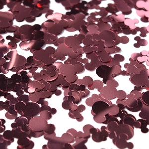 May include: A scattering of rose gold metallic confetti shaped like Mickey Mouse heads.