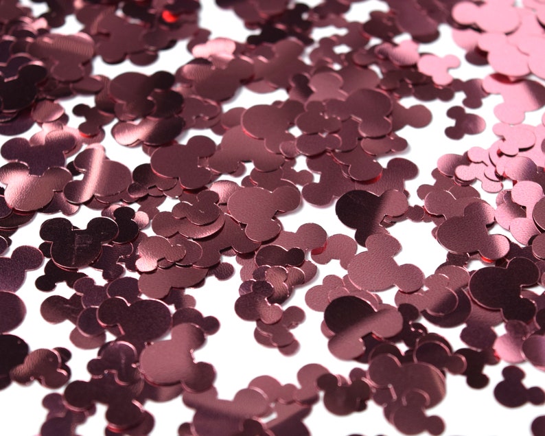May include: A scattering of rose gold metallic confetti shaped like Mickey Mouse heads.