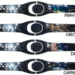 May include: Four different Disney MagicBand designs featuring characters from Guardians of the Galaxy. Each band has a black background with a white galaxy pattern and a character image. The characters are Mantis, Groot, Drax, and Gamora. The text "MANTYS", "GROOT", "DRAX", and "GAMORA" is printed below each character.