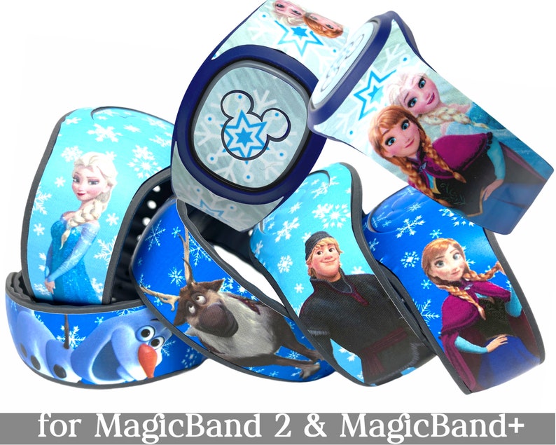 May include: Several blue MagicBand 2 and MagicBand+ wristbands featuring characters from the movie Frozen. The bands have images of Elsa, Anna, Olaf, Kristoff, and Sven, with snowflake and Mickey Mouse designs. Text at the bottom reads "for MagicBand 2 & MagicBand+".