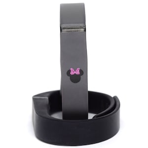May include: A black and gray fitness tracker with a pink Minnie Mouse design.
