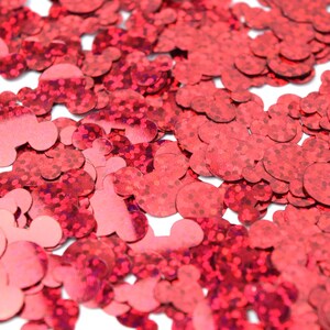 Op de afbeelding: Rode glitter confetti in de vorm van Mickey Mouse-koppen.