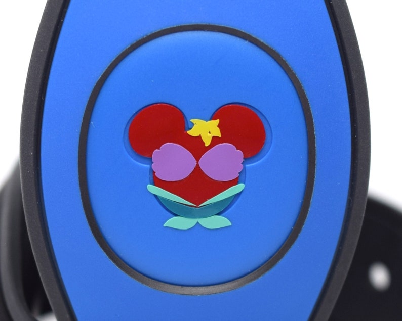 May include: A blue plastic Disney MagicBand with a red, yellow, and green Ariel the Little Mermaid character design.