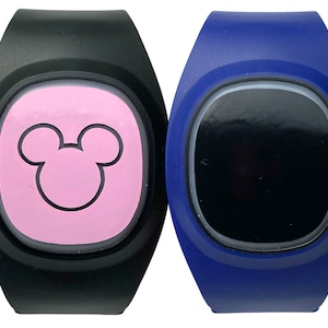 May include: Two wristbands, one black with a pink Mickey Mouse silhouette and one blue with a black screen.