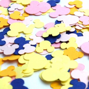 Puede incluir: Una dispersi&oacute;n de confeti en forma de cabezas de Mickey Mouse. El confeti es en tonos de amarillo, rosa y azul.