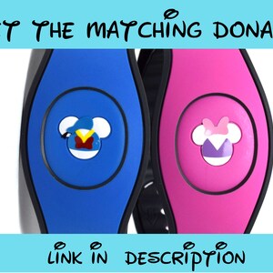 Op de afbeelding: Twee Disney MagicBands, een blauwe met een Mickey Mouse hoofd dat een blauwe hoed en een rood vest draagt, de andere roze met een Minnie Mouse hoofd dat een roze strik en een paarse jurk draagt. De tekst "GET THE MATCHING DONALD!" staat bovenaan de afbeelding en "LINK IN DESCRIPTION" staat onderaan.
