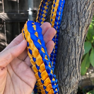 Customized Choose Your Colors Double Ribbon Graduation Lei Tied with a Kraft Tag of Graduate's Name Written in Cursive at the Center